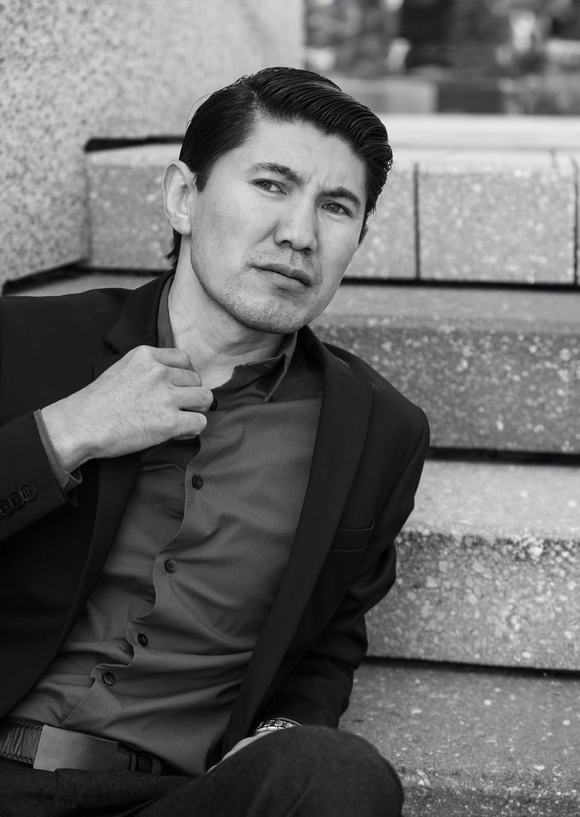 Black-and-white portrait of Medet Aman in a dark suit