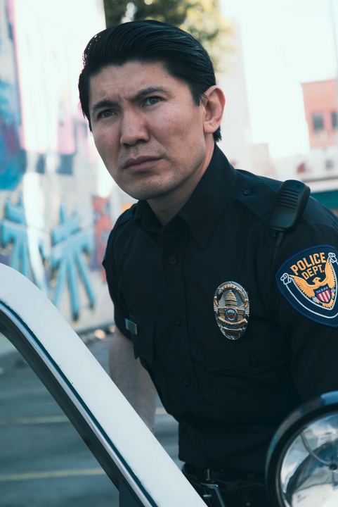 Close-up of Medet in police uniform looking past the camera